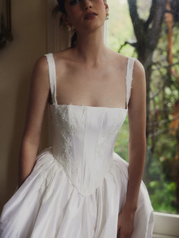 Close-up of a square-neck corset bodice wedding gown with delicate lace trim and wide straps at La Mariée Boutique Tulsa
