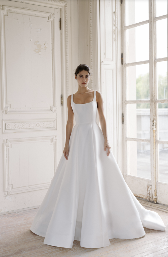 Minimalist square-neck satin A-line wedding gown with a full skirt and sweep train at La Mariée Boutique Tulsa
