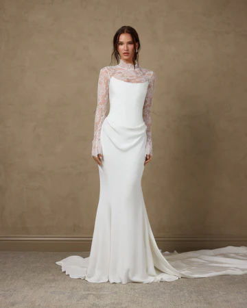Sleek crepe fit-and-flare wedding gown with a high lace neckline and sheer lace long sleeves at La Mariée Boutique Tulsa