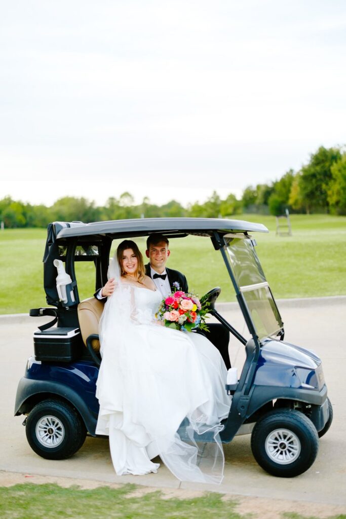 Bride and groom smiling on golf cart at Tulsa Country Club wedding reception
