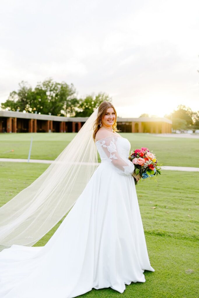 off-shoulder lace wedding gown with cathedral veil and colorful bridal bouquet at Tulsa Country Club