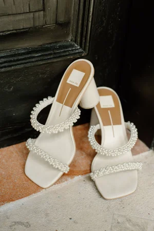 Bridal shoe detail: white block-heel mule sandals with double pearl-embellished straps