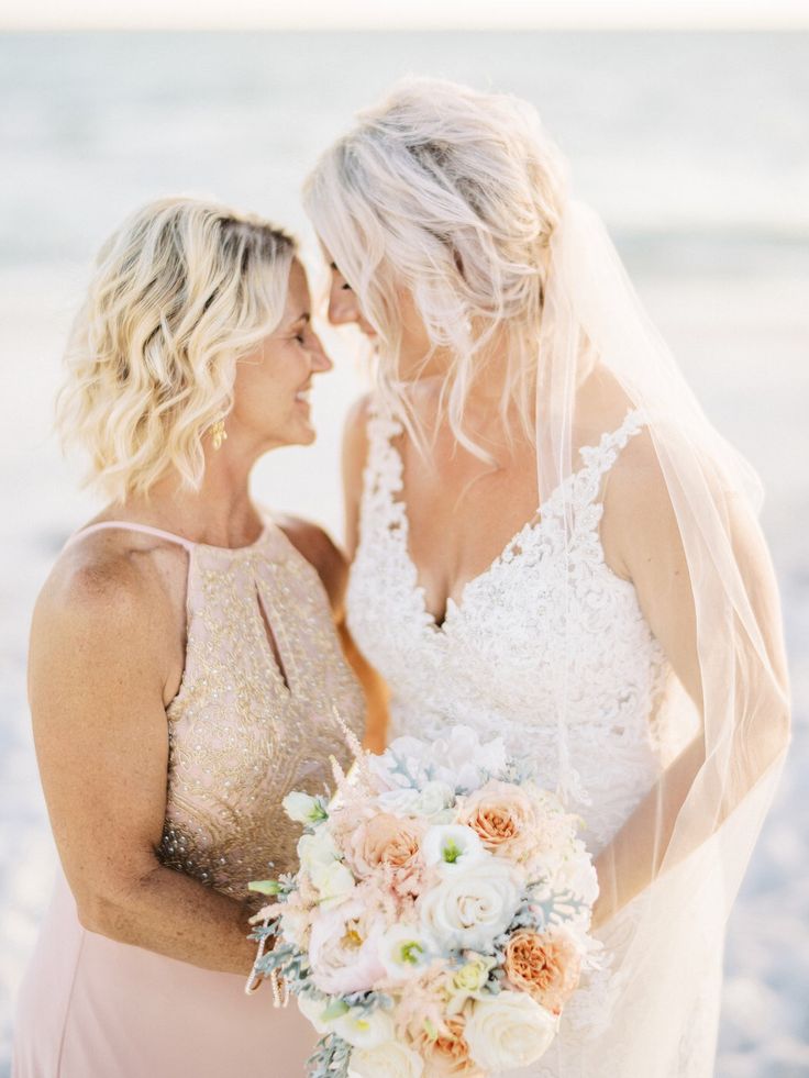 Mother and bride smiling for a portrait after a seaside ceremony